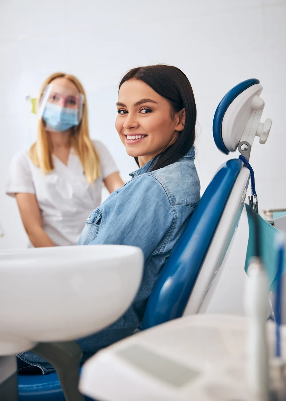 A young woman smiling in a dentist chair