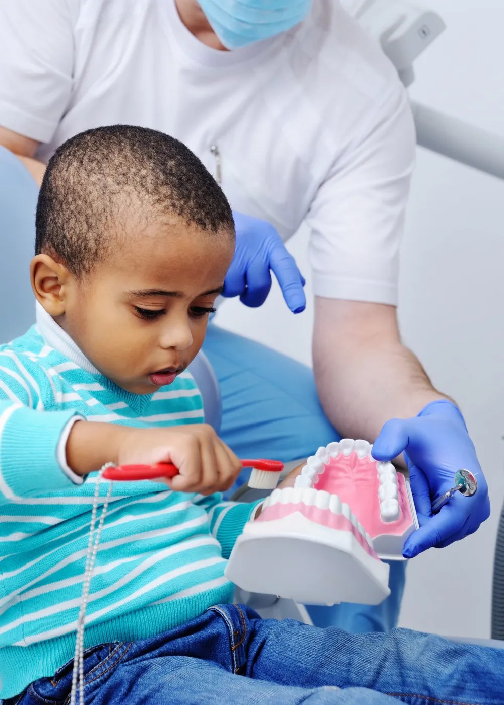 Young boy learning how to brush teeth